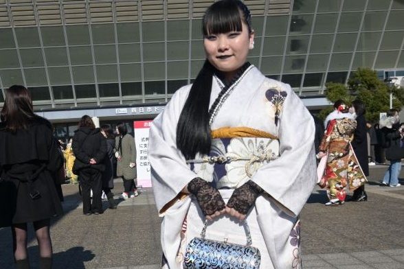 黒いレースの手袋をして、黒いリップを塗り白い振袖を着た女性