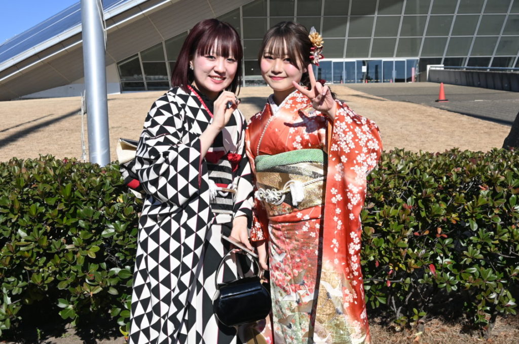 幾何学模様の振袖でボブヘアの女性と、古典柄の振袖の女性