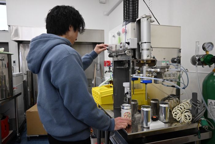 醸造所の工房でビールを缶に入れる近藤さん