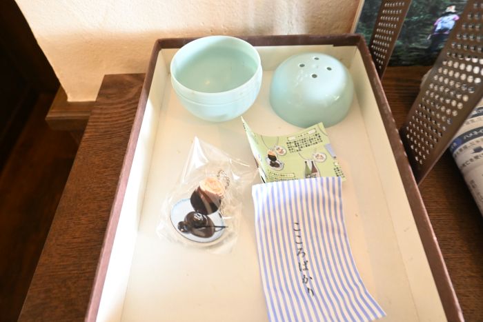 カプセルとカプセルの中に入っていたコーヒーゼリーのキーホルダーと、キーホルダーの説明、コーヒーチケットが入った「こころばかり」と書いた封筒